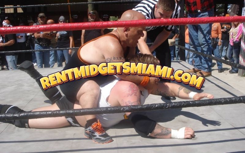 Micro wrestlers performing high energy wrestling moves in a Miami ring
